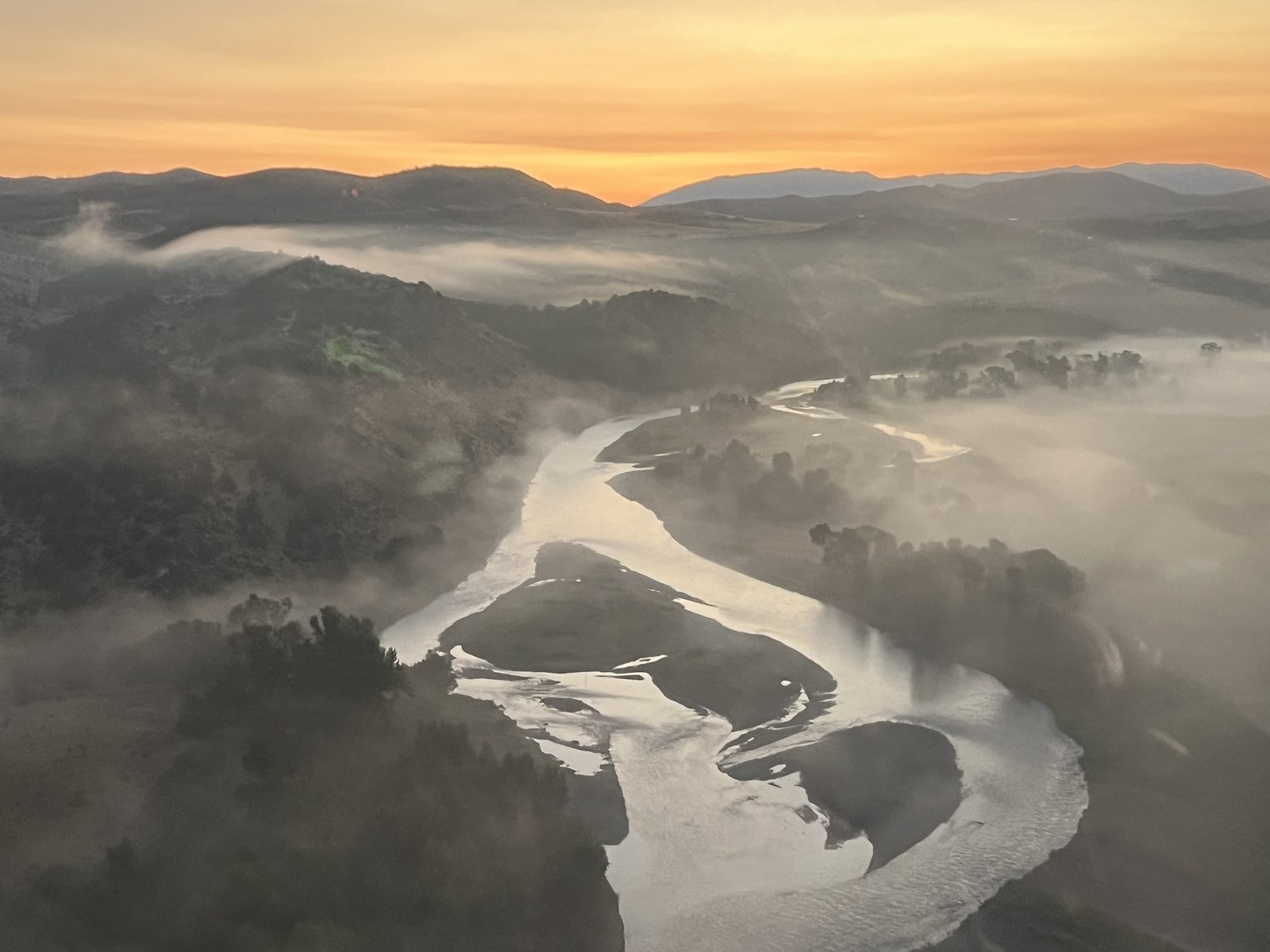 Aerial view of morning fog over the winding Madison River valley at sunrise